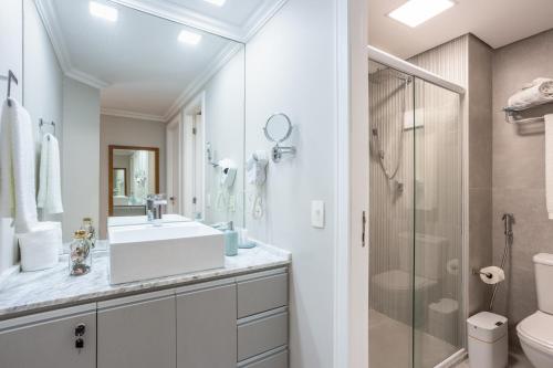 a white bathroom with a sink and a shower at Lindo Apartamento Alto Padrão Bela Cintra Stay in Sao Paulo