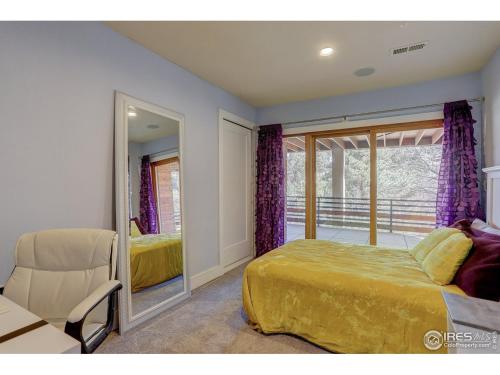 a bedroom with a bed and a window and a chair at Sunshine Daydream Boulder Mountain Home - walk to Pearl St. / hiking in Boulder