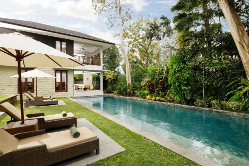 een huis met een zwembad en een villa bij OMEKALI Canggu by Nakula in Canggu