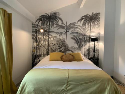 - une chambre avec un lit recouvert de palmiers dans l'établissement Villa la bastide piscine et jacuzzi, à Silhac
