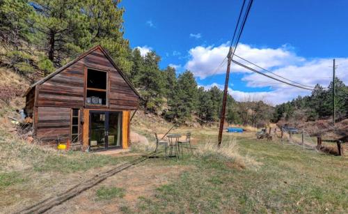 a small cabin with a table and chairs in a field at Sunshine Daydream Boulder Mountain Home - walk to Pearl St. / hiking in Boulder