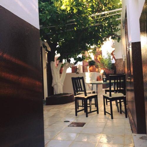 a patio with chairs and a table with a person in the background at Villa Elena in Líndos