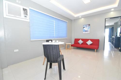 a dining room with a table and a red couch at Blue Suites Boracay in Boracay