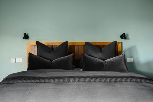 a bedroom with a large bed with black pillows at The View Bright - Apartment 1 in Bright