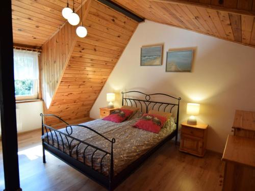 une chambre avec un lit dans une pièce avec des plafonds en bois dans l'établissement Holiday Home in Kopalino near Baltic Sea, à Kopalino
