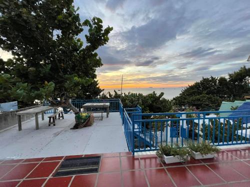 a blue railing on a balcony with a view of the ocean at Má Năm Homestay in Phương Phi