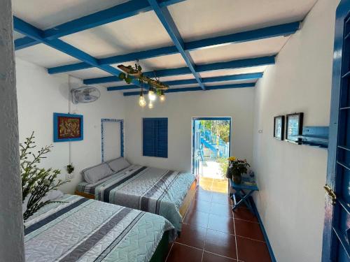 2 camas en una habitación con vigas azules en Má Năm Homestay, en Phương Phi