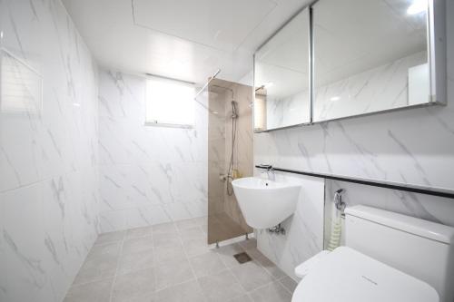 a white bathroom with a toilet and a sink at HOTEL LENITH Seomyeon in Busan