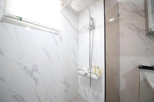 a bathroom with a shower with white marble walls at HOTEL LENITH Seomyeon in Busan