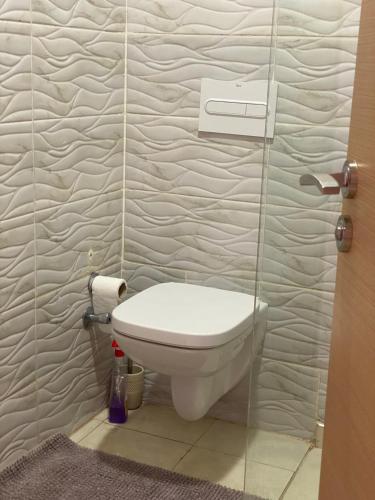 - Baño con aseo y pared de cristal en Appartement Dahomey Bouznika, en Bouznika