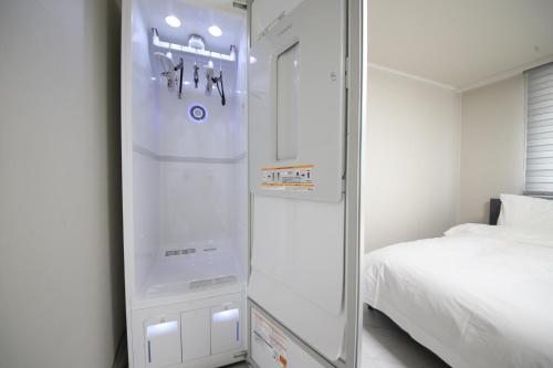 釜山にあるHOTEL LENITH Seomyeonのベッドの横の部屋に冷蔵庫が備わります。