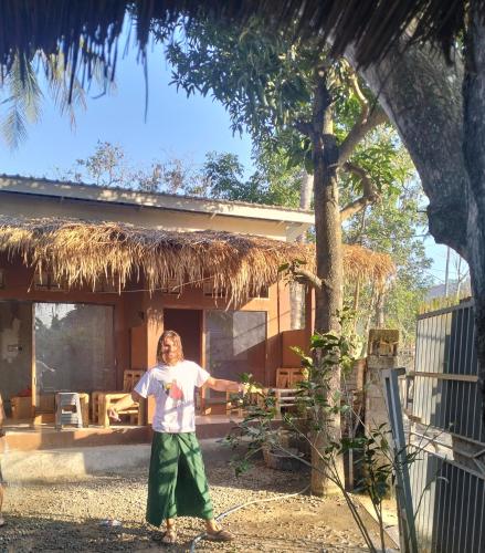 a woman standing in front of a house at Fullmoon homestay in Kuta Lombok