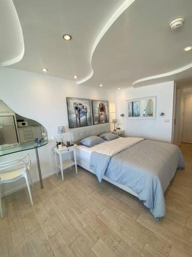 a bedroom with a large bed and a desk at ruth’s balcony sea view apt in Herzliya B