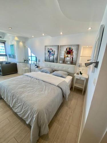 een slaapkamer met een groot bed in een kamer bij ruth’s balcony sea view apt in Herzliyya B