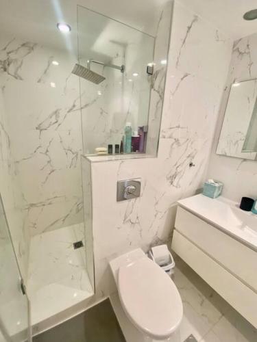 biała łazienka z toaletą i prysznicem w obiekcie ruth’s balcony sea view apt w mieście Herzliya