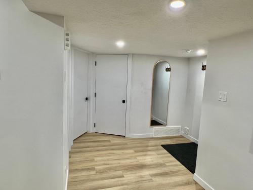 a hallway with a mirror and white walls at Vinash Luxury Suite in Edmonton