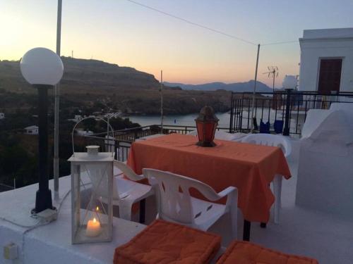 a table and chairs on a balcony with a view at Villa Elena in Líndos