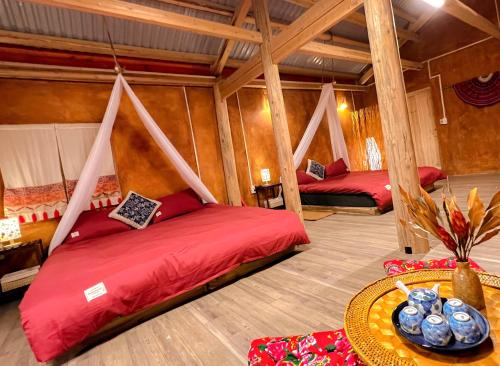 a room with two beds and a table in a room at Chìu Pa Homestay in Loung Co