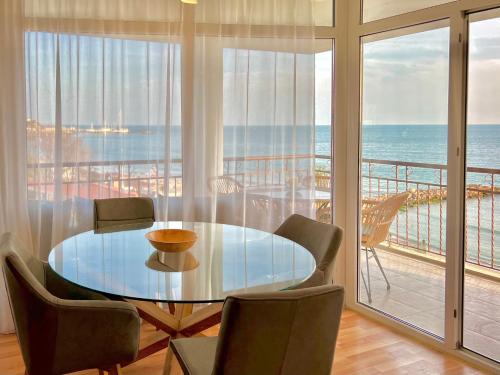 a dining room with a table and a view of the ocean at Beachfront Havana in Sveti Vlas