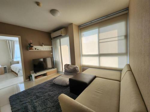 a living room with a couch and a television at 2 Bedrooms 2 bath Apartment in Chiang Mai