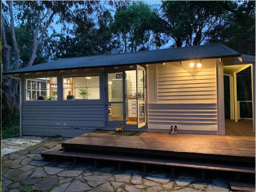 una casa pequeña con porche y terraza en Charming Country Retreat, en Hamilton