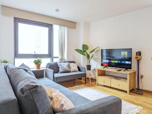 ein Wohnzimmer mit einem Sofa und einem TV in der Unterkunft 2-bedroom Apt Near Key Attractions Free Parking in Liverpool