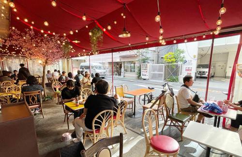 a group of people sitting at tables in a restaurant at Sakura Hotel Ikebukuro in Tokyo