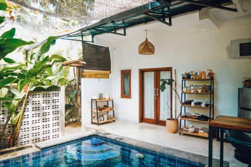 een huis met een zwembad in een tuin bij Panayota House in Kuta Lombok