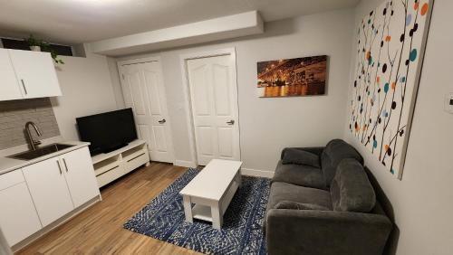 sala de estar con sofá y TV en Charming East Van Hideaway - Near SkyTrain, en Vancouver