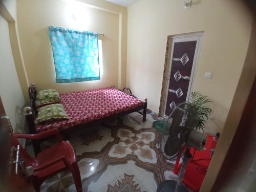 sala de estar con banco rojo y ventana en Ghosh homestay, en Calcuta