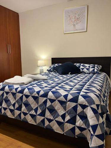 Una cama azul y blanca en un dormitorio en Departamento de 2 Habitaciones, full amoblada con todo para que disfrutes de tu Estancia en Cuenca