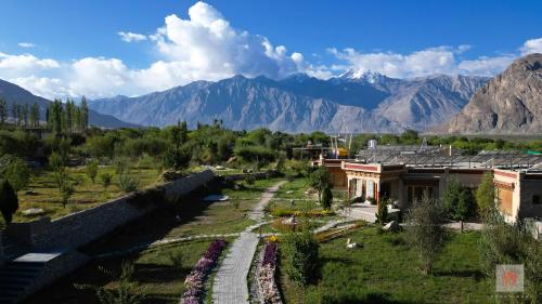 een luchtzicht op een dorp met bergen op de achtergrond bij Lchang Nang Retreat-THE HOUSE OF TREES in Nubra