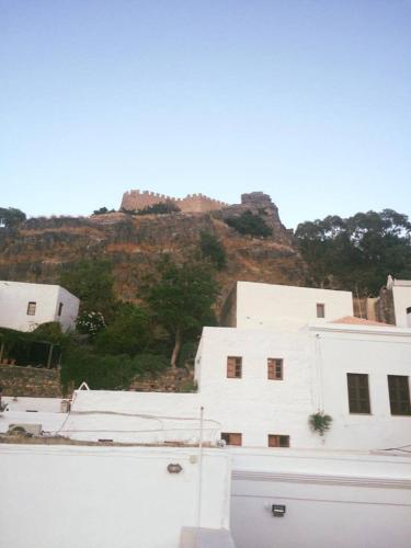 a white building with a mountain in the background at Villa Elena in Líndos