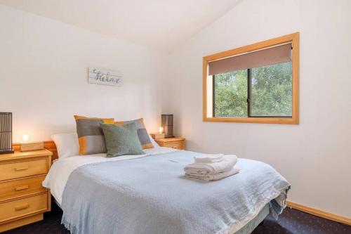 ein Schlafzimmer mit einem großen Bett und einem Fenster in der Unterkunft Peaceful Bruny Island Shack in Dennes Point