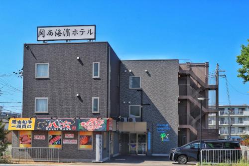 a building with a sign on top of it at Kansai Seaside Hotel in Kaizuka