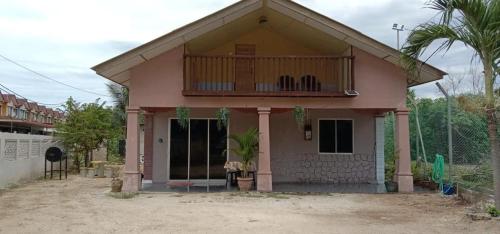 a small house with a balcony on top of it at Homestay D'Hiburan Kuala Rompin in Kuala Rompin