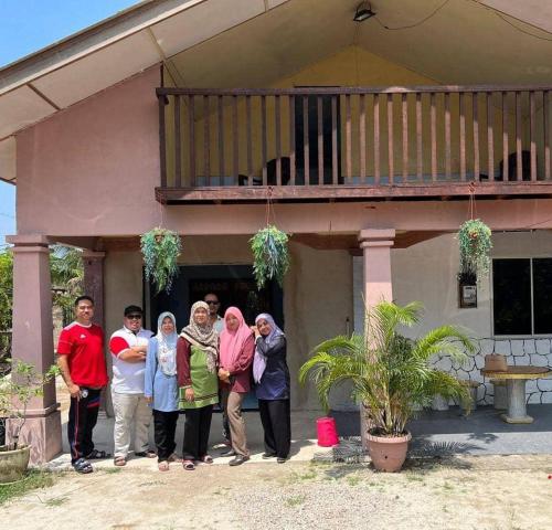 a group of people standing outside of a house at Homestay D'Hiburan Kuala Rompin in Kuala Rompin
