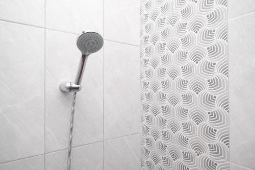 La salle de bains est pourvue d'une douche avec un pommeau de douche. dans l'établissement DR Living Syariah Solo Mitra RedDoorz, à Kadiporo
