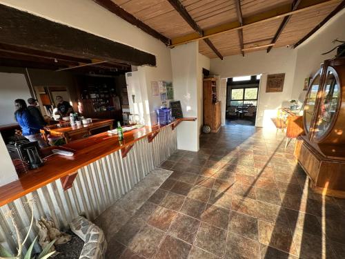 a room with a bar and a person at a counter at CORAM DEO SaltyWaves double en-suite rooms with sea views in Coffee Bay