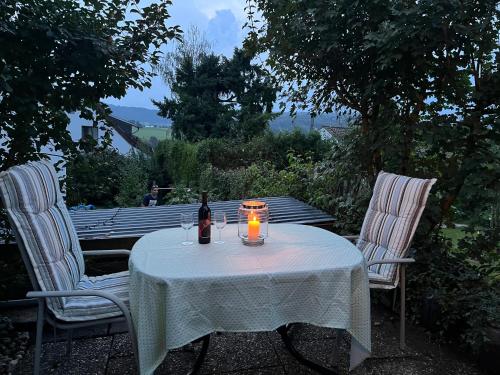 uma mesa com uma garrafa de vinho e uma vela em Ferienwohnung-Weil-Burg em Weilburg