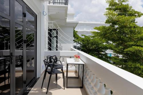 a balcony with a table and chairs on a building at SUNRISE Hotel Bạc Liêu in Bạc Liêu