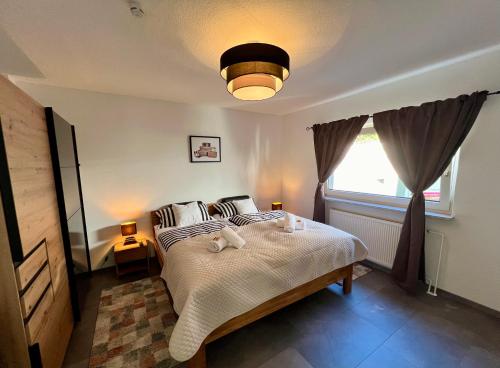 ein Schlafzimmer mit einem Bett mit zwei ausgestopften Tieren darauf in der Unterkunft Ferienhaus am Bach Koblenz in Koblenz
