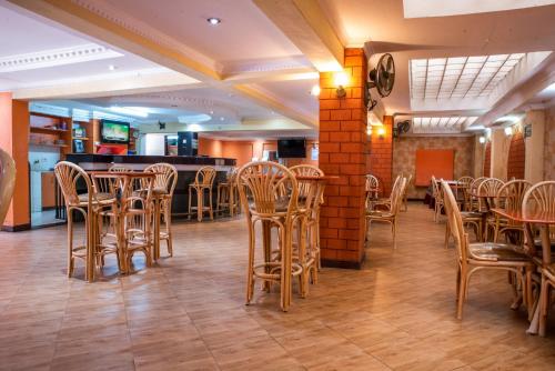 ein Restaurant mit Holzstühlen und Tischen sowie eine Bar in der Unterkunft Jupiter Guest Resort - Langata in Nairobi