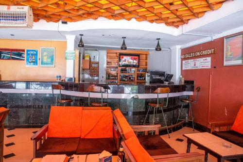 un bar en un restaurante con sillas naranjas en Jupiter Guest Resort - Langata, en Nairobi