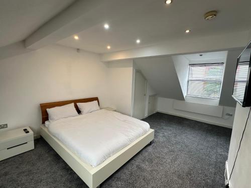 a bedroom with a white bed and a window at Homestay with free wi-fi, parking and more in Darlington