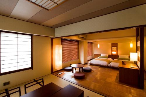 a bedroom with a bed and a desk and a table at 焼津グランドホテル in Hanazawa
