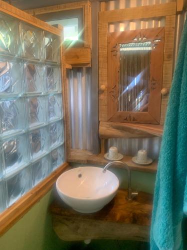 bagno con lavandino bianco e specchio di Lily Pad lodge a Rodrigues Island