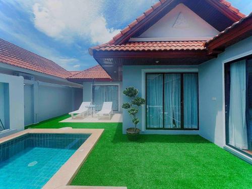 une maison avec une cour et une piscine dans l'établissement Pattaya Jomtien Private Luxury Pool Villa 芭堤雅中天豪华私家泳池别墅, à Jomtien Beach