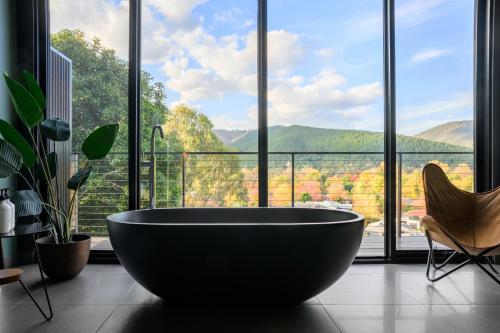 a large bath tub in a room with a large window at The View Bright - Apartment 1 in Bright