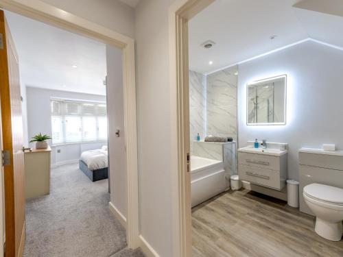 a bathroom with a tub and a toilet and a sink at Pass the Keys 40C 2 bed Celosia Beautiful Town Centre Apartment in Shrewsbury